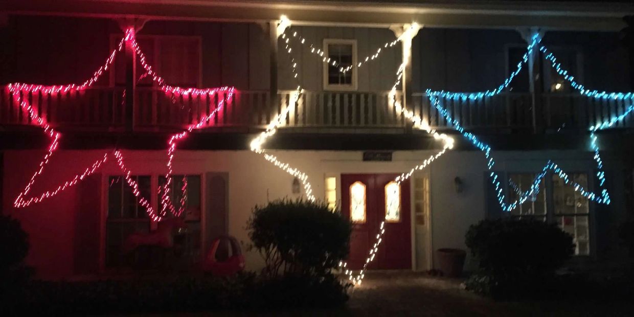 Huge, 2 story Christmas Lights in red, white and blue to form 3 shooting stars for July 4th celebrat