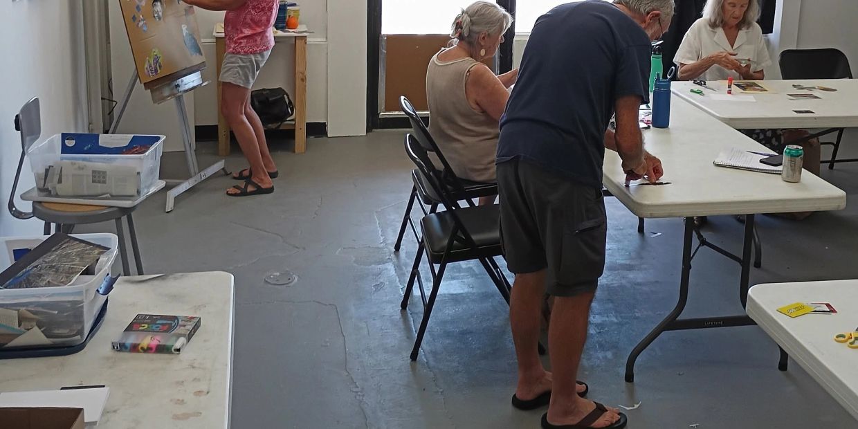 Adults engaged in an art or craft activity in a studio room.