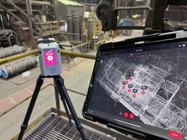 3D scanning setup with a tablet and a scanner in an industrial setting.