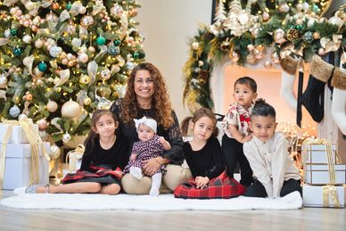 Family portrait by Christmas tree with gifts