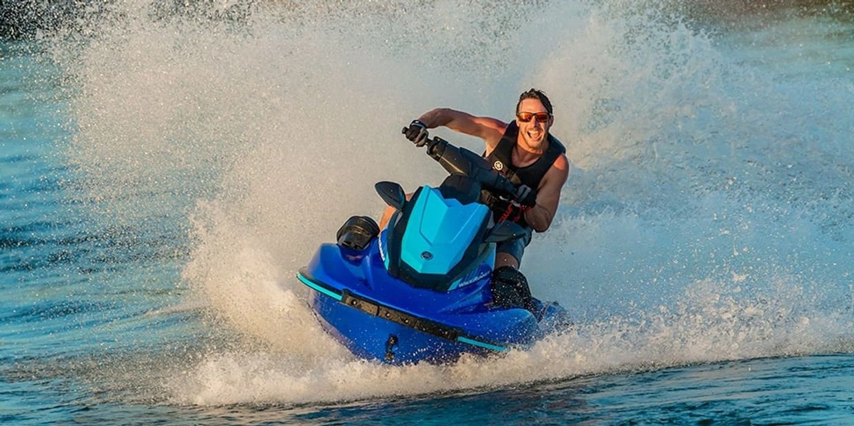 A colorful sunset over a calm sea with silhouettes of palm trees in the foreground.