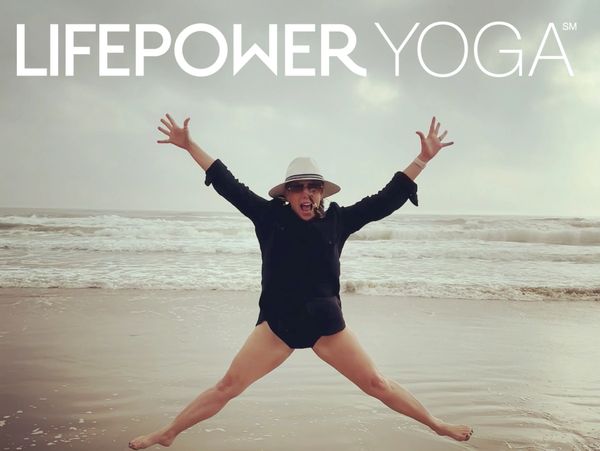 Person joyfully jumping on a beach with LIFEPOWER YOGA text above.