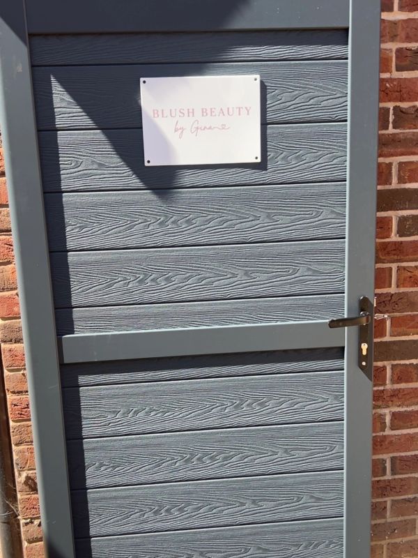 Grey door with a 'Blush Beauty by Grace' sign.