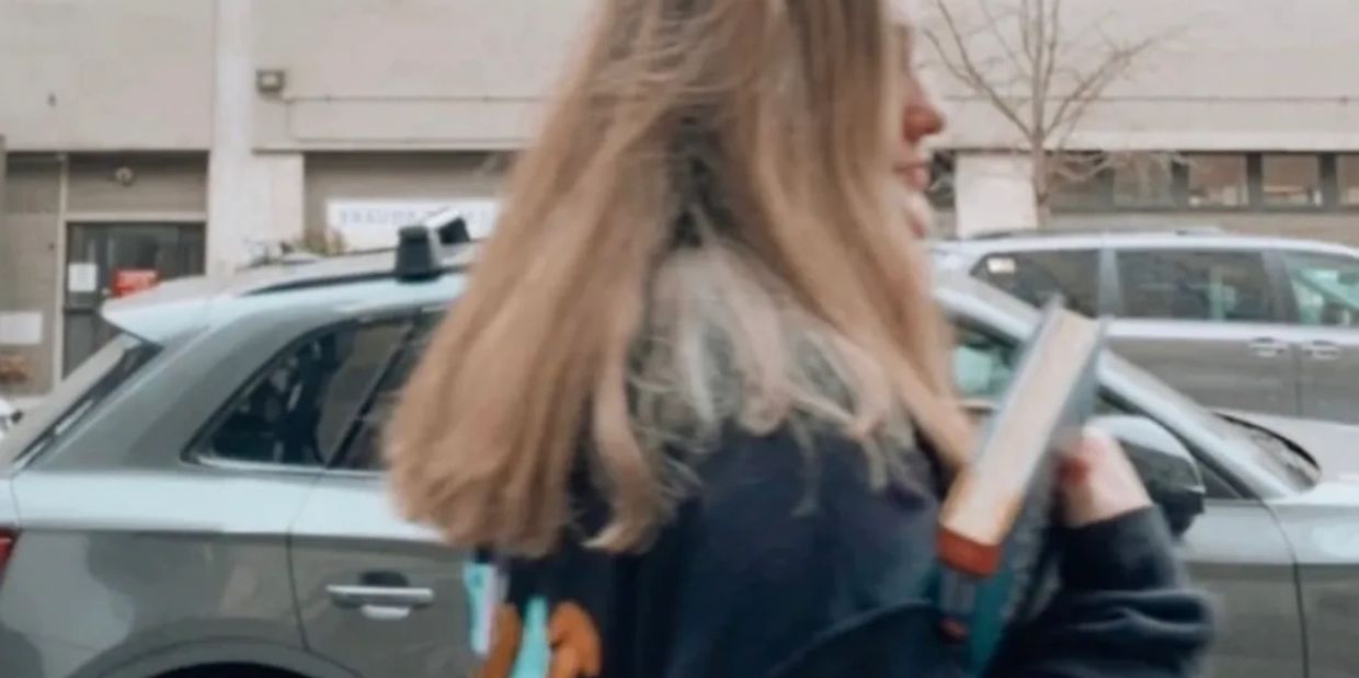 Woman walking with book.