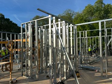Metal framework being constructed outdoors on a sunny day.