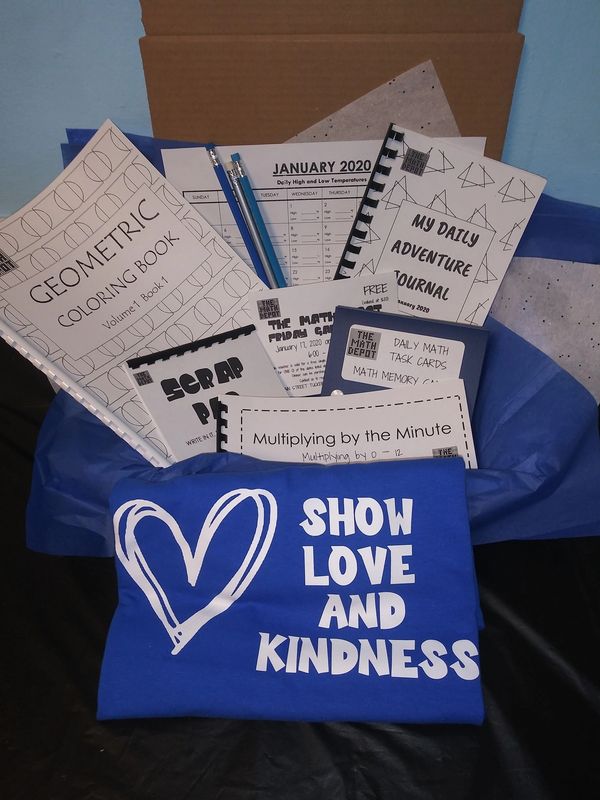 A gift box with educational materials and a blue shirt saying 'Show Love and Kindness'.
