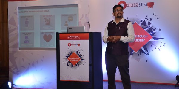 Man giving a presentation on leadership skills at an ICICI Bank event.