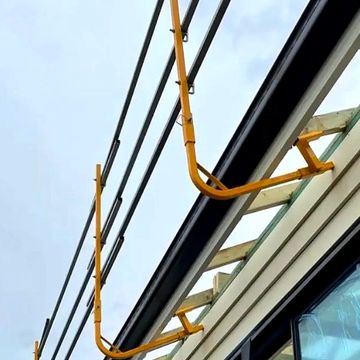 Yellow metal pipes attached to a building.