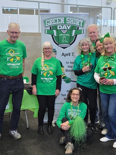 Group of people wearing green shirts for Green Shirt Day event in an indoor venue.