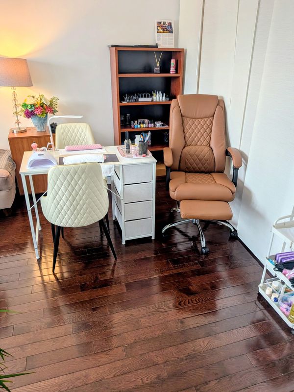 A cozy nail salon workspace with chairs and nail care items.