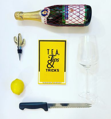 Book photography with wine, a gold cactus wine bottle stopper - Biodun Abudu's  Tea,Tips & Tricks. 