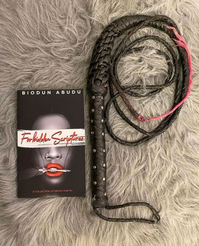 An erotic book photoshoot for forbidden scriptures written by biodun abudu and a black whip