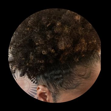 Close-up of a head with tightly coiled, curly hair.