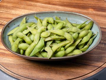 Many edamame in an oval bowl.