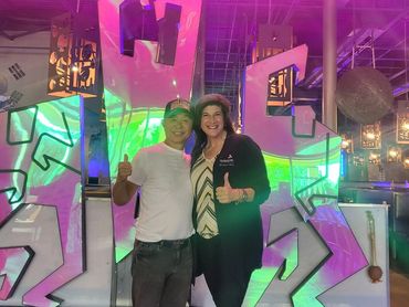 Two people smiling and sticking their thumbs up.