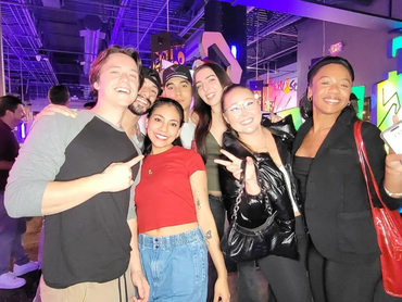 A group of smiling people gesturing the peace sign with their hands.