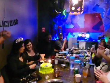 A group of people in the private karaoke room celebrating a birthday.