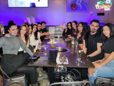 A group of people smiling while seated at their table.