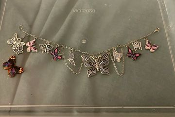 Silver butterfly charm bracelet with colorful and engraved butterfly charms.