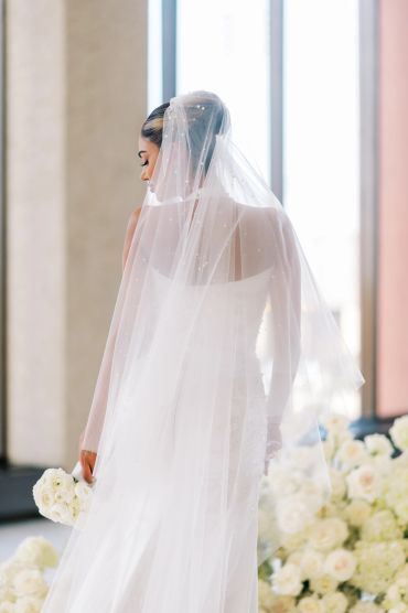 Bride in a white dress with a veil holding a bouquet.