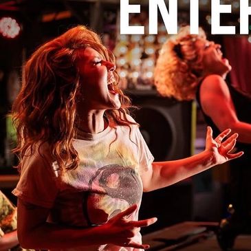 Women passionately rock singing on stage.