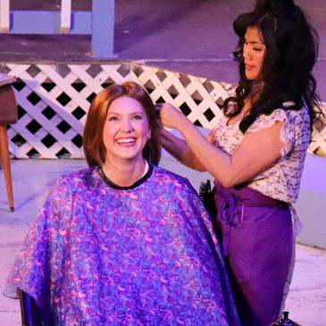 Woman getting a haircut and smiling.