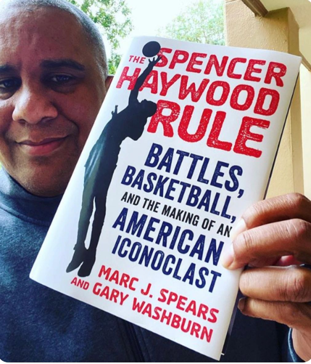 Marc Spears holding up his book; Credit Tom Haberstroh