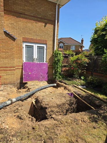 Backyard under construction with a dug-up garden and a covered door.
