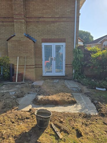 Construction site in front of a brick house with white double doors.