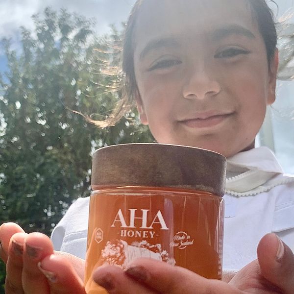 My daughter holding a honey jar.