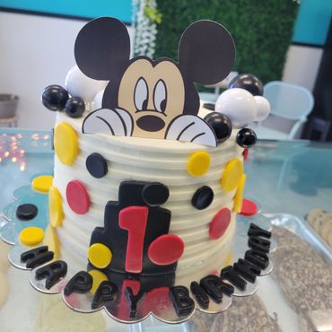 A white colored cake with mickey mouse 