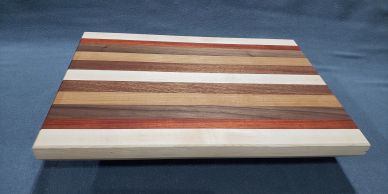 Striped wooden cutting board with various wood tones.