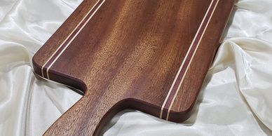 Elegant wooden cutting board with striped inlays.