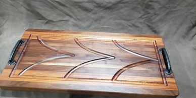 Wooden tray with curved groove design and handles.