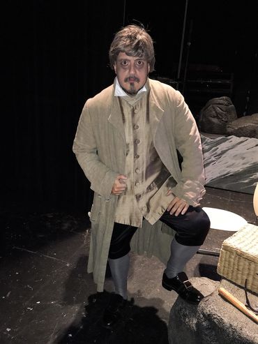 Person in historical costume poses on stage.