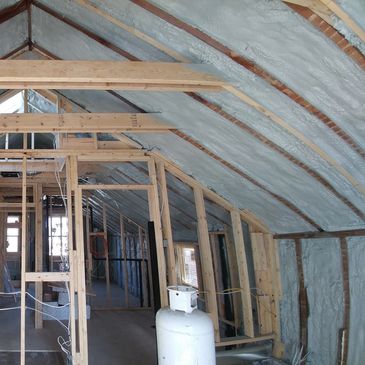 Interior view of a space with exposed wooden beams and construction materials.