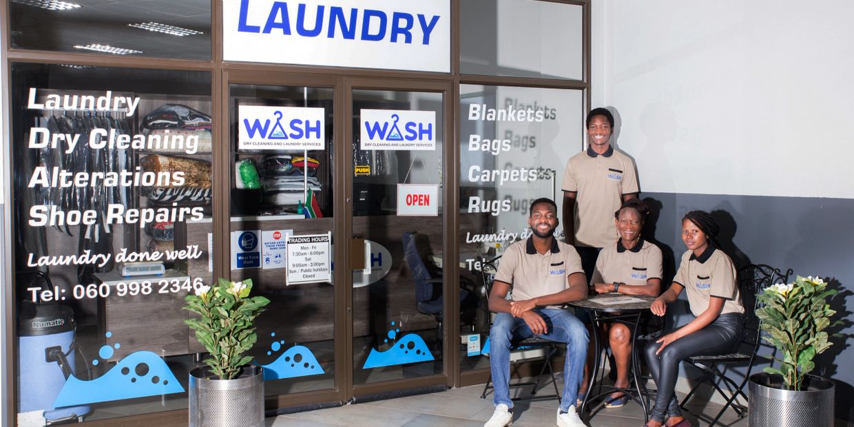 Staff members of a dry cleaning and laundry company in Midrand South Africa sitting outside the stor