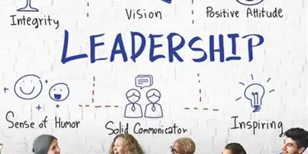 Team discussing leadership qualities written on a wall.