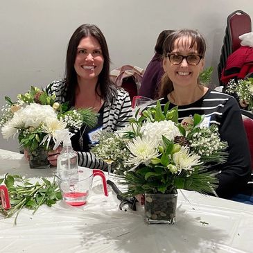 Two women smiling at a flower workshop put on by Elite Events BC