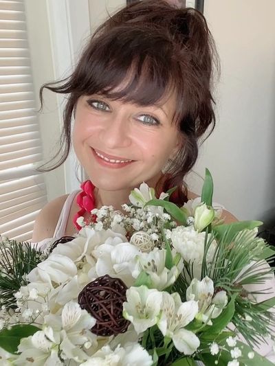 Elena Markin - owner of Elite Events BC, holding a beautiful floral arrangement she created.