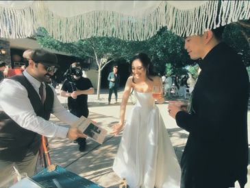 Bride and groom enjoying a magic show at their wedding reception outdoors.