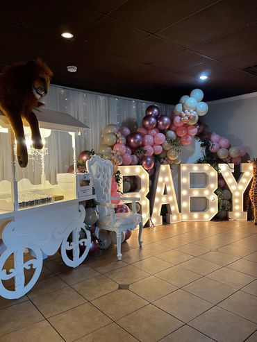 Decorative baby shower setup with lights and balloons.