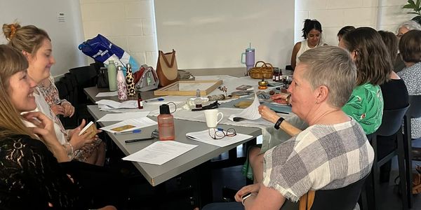 Women engaged in a self-care workshop activity during a facilitated group event in Adelaide.
