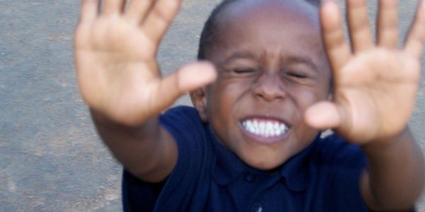 Young Ethiopian boy raises his hands in joy