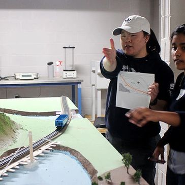 People discussing a model train setup.