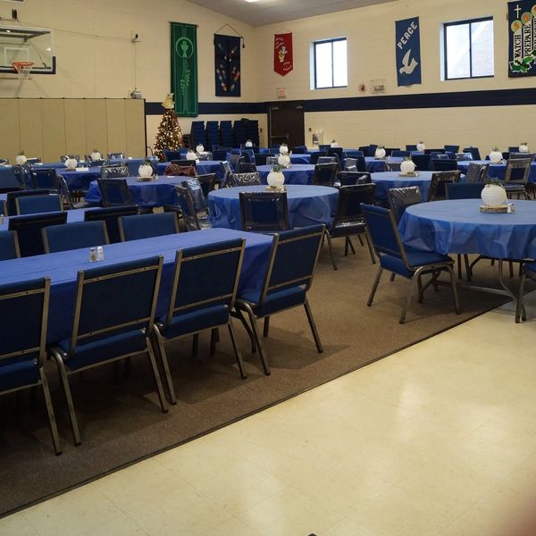 Tables and chairs set up in a decorated gymnasium.
