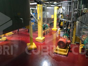Industrial room with yellow pillars and red shiny floor.