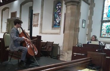Young musician playing cello in a church.