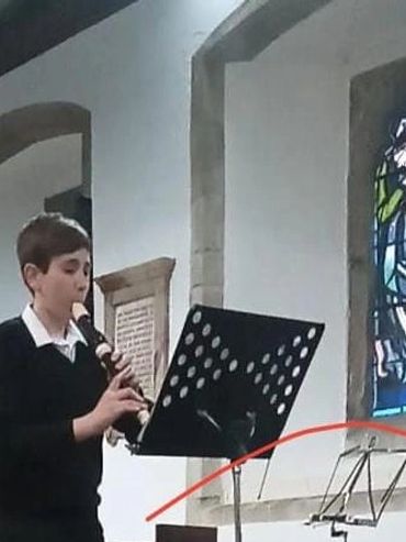 Boy playing a recorder in a church.