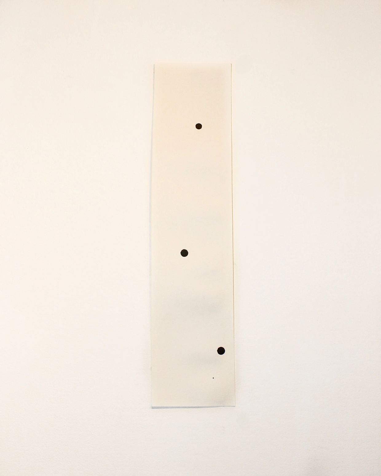 Minimalist artwork with four black dots on a vertical white strip.